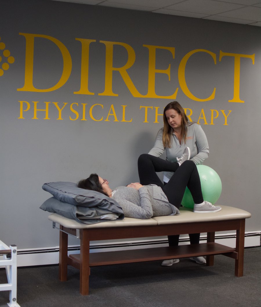 Physical therapist with patient and exercise ball on therapy table in Yonkers